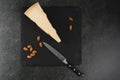 An appetizing solid cheese on a black plate on a gray stone background Royalty Free Stock Photo