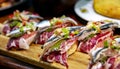 Appetizing spanish tapas with jamon, anchovies and green vegetables