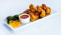 Appetizing spicy baked chicken wings with sweet chili sauce on t