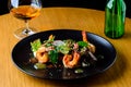 Appetizing spicy salad with shrimps, radish and sauce on the tab