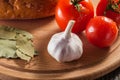 Appetizing still life of vegetables bread and seasoning on a wooden board Royalty Free Stock Photo