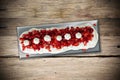 Appetizing strawberry Pavlova cake on wooden table with metallic plate Royalty Free Stock Photo