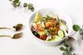 Appetizing summer salad with fresh vegetables, fried shrimps, cheese and herbs. Seasonal vegetables, seafood and goat cheese. Royalty Free Stock Photo