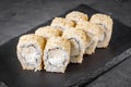 Appetizing sushi roll with Philadelphia tofu sesame cheese on a black stone plate