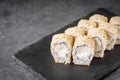 Appetizing sushi roll with Philadelphia tofu sesame cheese on a black stone plate