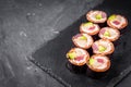 Appetizing sushi roll with tuna salmon escolar crab and avocado on a black stone plate