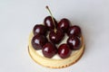 Appetizing tartlet with cherry is lying on the desk.