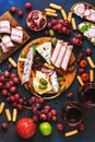 Appetizing a variety of appetizers-red wine, fruit, cheese, sausage on a blue background. Italian or Spanish snacks. The view from Royalty Free Stock Photo