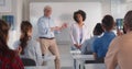 Applauding students and teacher congratulating their groupmate after speech in classroom Royalty Free Stock Photo