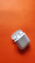 White Apple airpods, in Orange background, airpods with case in a background, headphones Wallpaper photos. Royalty Free Stock Photo