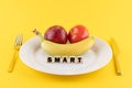 Apple, a banana and a tomato on a plate and the word 'smart' written on wooden blocks Royalty Free Stock Photo