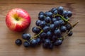 Apple And Black Grapes On Wood Background