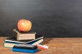 Apple, Books and Chalks with Blackboard Background