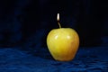 Apple candle on velor dark background Royalty Free Stock Photo