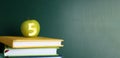 Apple with carved number five as school grade on books near green chalkboard. Banner design with space for text Royalty Free Stock Photo