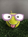 Apple character wearing glasses on a grass background