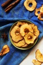 Apple chips and cinnamon on white wooden table. Homemade dry baked fruit slices, autumn fall snack, healthy vegan food