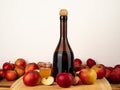 Apple cider vinegar in a bottle with apples against a white wall. Royalty Free Stock Photo