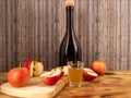 Apple cider vinegar in a bottle with apples on a wooden background. Royalty Free Stock Photo