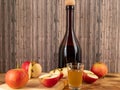 Apple cider vinegar in a bottle with apples on a wooden background. Royalty Free Stock Photo