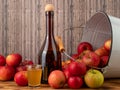 Apple cider vinegar in a bottle with apples on a wooden background. Royalty Free Stock Photo