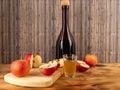 Apple cider vinegar in a bottle with apples on a wooden background. Royalty Free Stock Photo