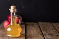 Apple Cider Vinegar in Glass Bottle and Red Fresh Apples Wooden Background Copy Space Royalty Free Stock Photo