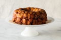 Apple cinnamon pull apart cake on a pedestal stand, against a light background.