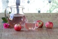 Apple compote in a transparent jug both fresh apples and a rose