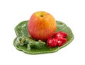 Apple on decorative dish with lizard and cow, isolated