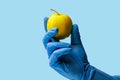 An apple in the doctor& x27;s hand. Background, selective focus. blue medical backdrop
