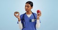 Apple, donut and doctor in studio with choice for healthy eating, diet and detox on blue background. Thinking Royalty Free Stock Photo