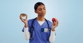 Apple, donut and nurse in studio with choice for healthy eating, diet and detox on blue background. Thinking, healthcare Royalty Free Stock Photo