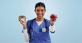 Apple, donut and portrait of nurse with choice for healthy eating, diet and detox on blue background. Happy, healthcare Royalty Free Stock Photo