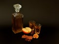 Apple-fig liqueur with spices on a black background, ripe fruits, cinnamon and anise, crystal glassware with homemade strong