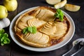 Apple french pie: temptation on black background. Traditional open pie with sliced thin parts of apples, decorated with mint