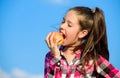 Apple fruit diet. Kid hold ripe apple sunny day. Kid girl with long hair eat apple blue sky background. Healthy Royalty Free Stock Photo