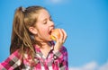 Apple fruit diet. Kid hold ripe apple sunny day. Kid girl with long hair eat apple blue sky background. Healthy Royalty Free Stock Photo