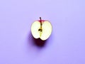 Apple fruit sliced by half isolated in studio over a pastel violet background