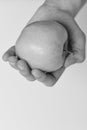 Apple fruit on white background, selective focus. Male hand holds light green apple. Health and nutrition concept.