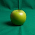 Apple with a glossy surface is centrally placed on a green fabric Royalty Free Stock Photo