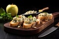 apple gorgonzola bruschetta with a kitchen knife and fresh basil leaves on a dark board