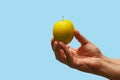 An apple in hand. Background, selective focus. Isolated blue medical backdrop