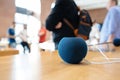 Apple Home Pod mini in modern meeting room with defocused people workers in