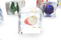 Apple in ice cube isolated on white with depth of field effects. Ice cubes with fresh berries. Berries fruits frozen in