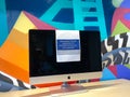 An Apple iMac computer that has a sign that reads removed from service to promote social distancing