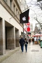 Apple Inc. logo on modern building facade above entrance, bitten white apple on black background, symbol of hardware store,