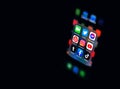 Apple iPhone black smartphone showing the Social Media icons bundle, closeup