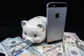 Selinsgrove, PA, USA - March 31, 2019 : An Apple iPhone sits on top of a pile of United States currency.