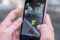 Apple iPhone5s with Pikachu from Pokemon Go application, hands of a teenager playing